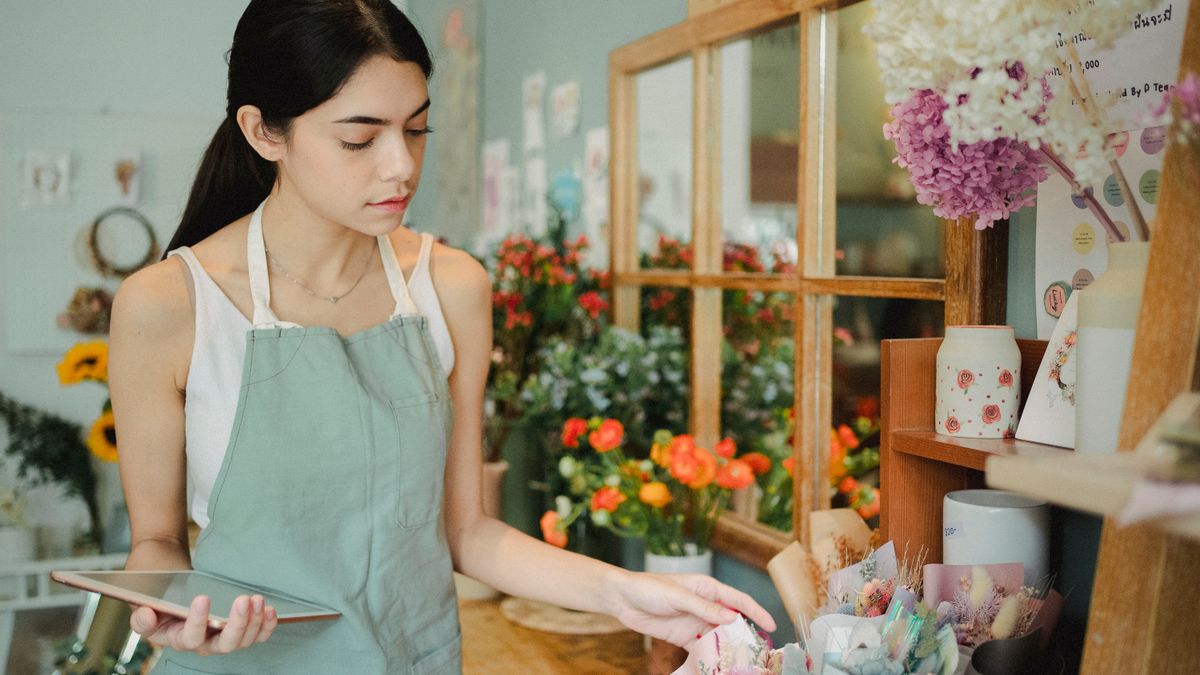 Propietaria de una floristería revisando su negocio con una tablet, ejemplo de buyer persona de pyme local